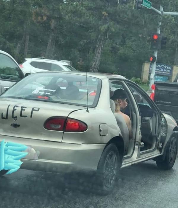 A gold sedan with the word jeep written in black marker on the trunk missing its doors.