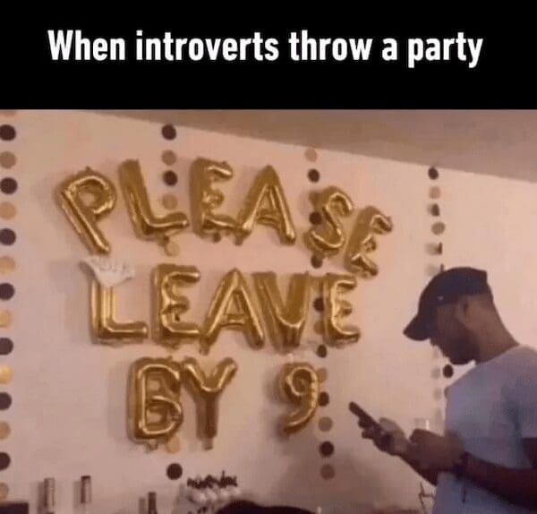 An excellent introvert meme tracking gold foil party balloons that bluntly spell out "PLEASE LEAVE BY 9" on a living room wall as a party attendee checks his phone.