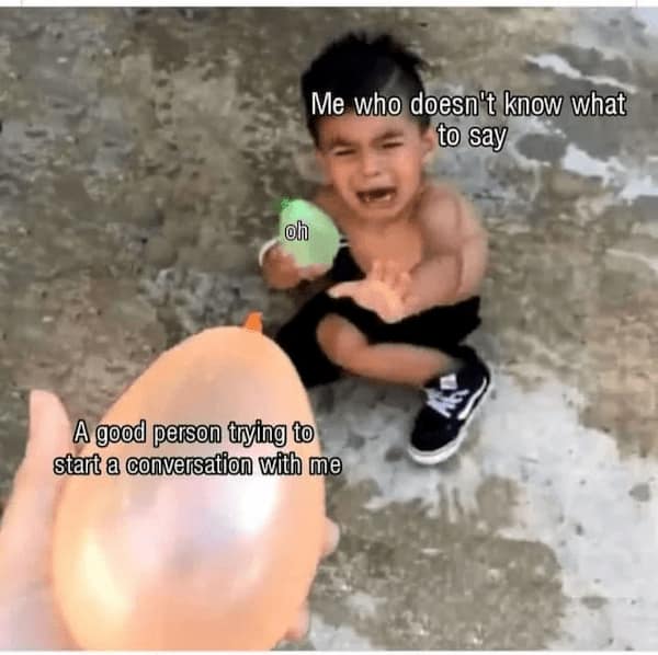 An awkward-interaction introvert meme depicting a crying toddler holding a green water balloon labeled "oh" away from an incoming orange water balloon labeled "A good person trying to start a conversation with me" under the header, "Me who doesn't know what to say."