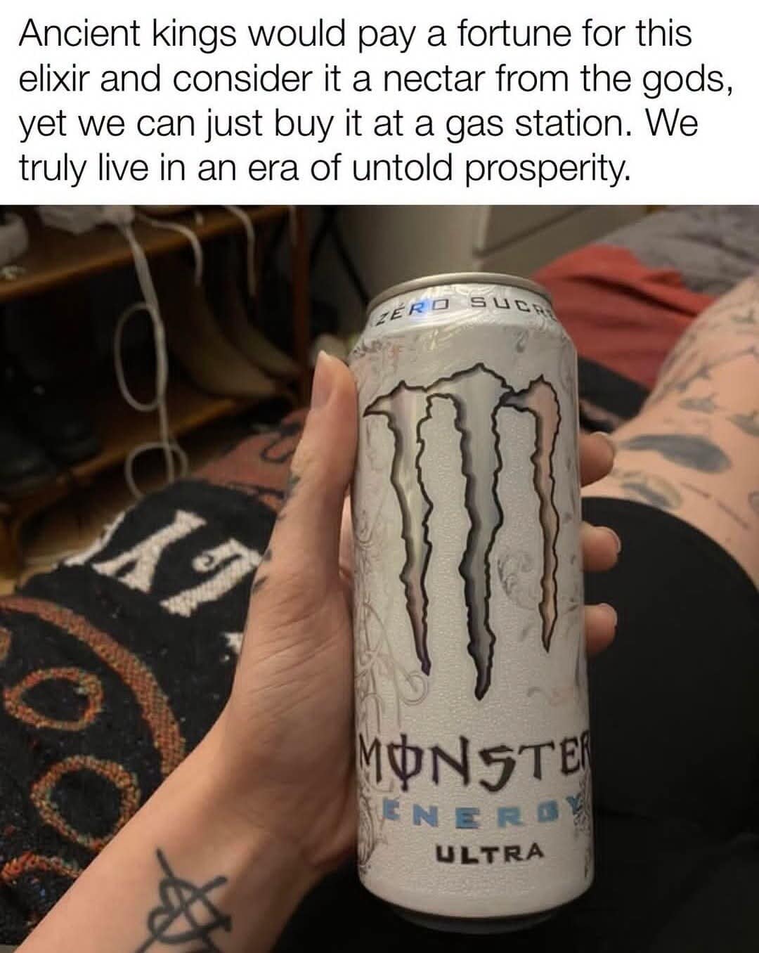A first-person perspective image in a meme dump showing a tattooed individual holding a white can of Monster Energy Ultra ("Zero Sucre"), topped with an over-glorified caption framing it as a nectar from the gods that ancient kings would pay a fortune to possess.