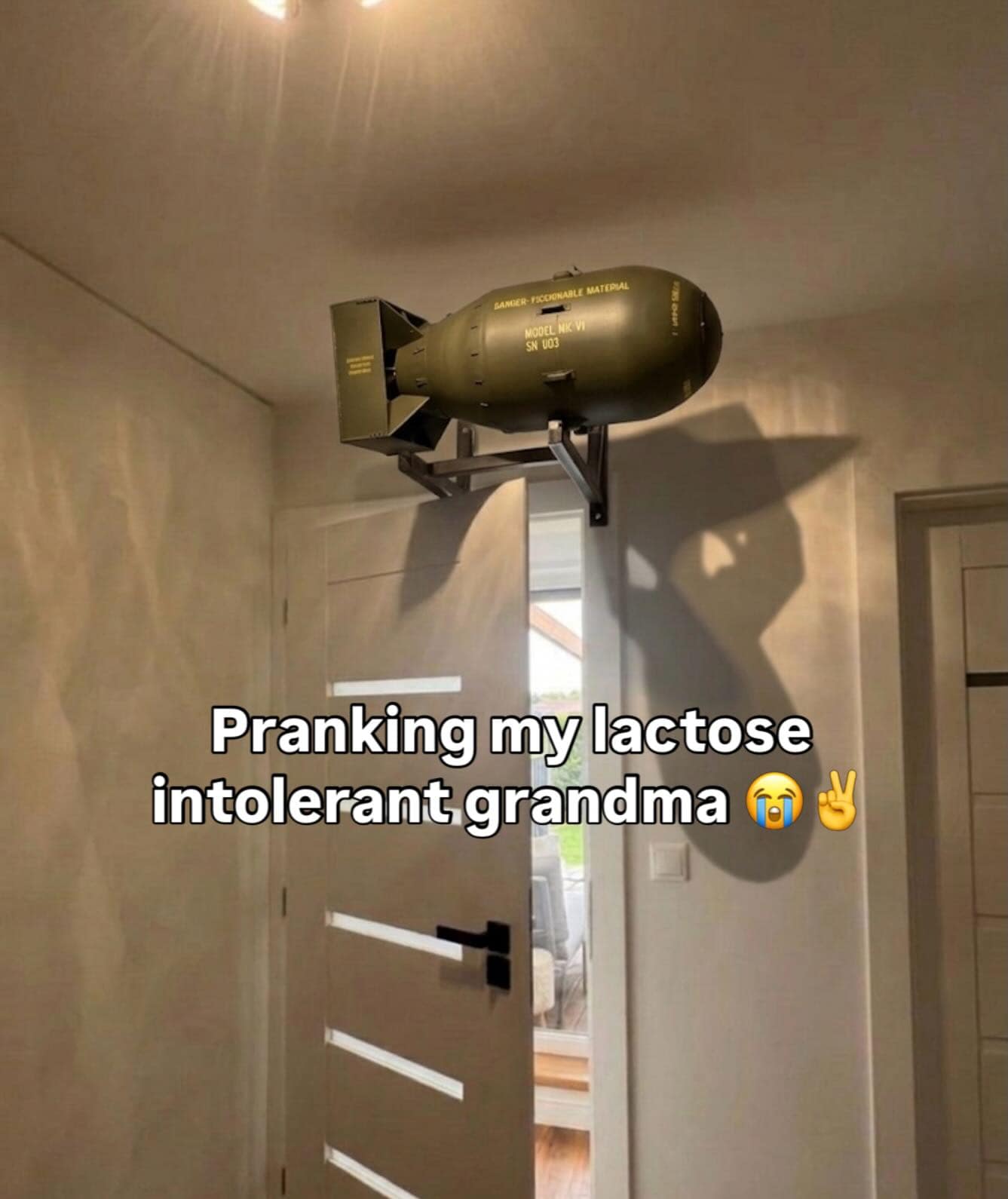 Nuclear bomb replica mounted above a residential doorway in a prank text graphic from an online meme dump.