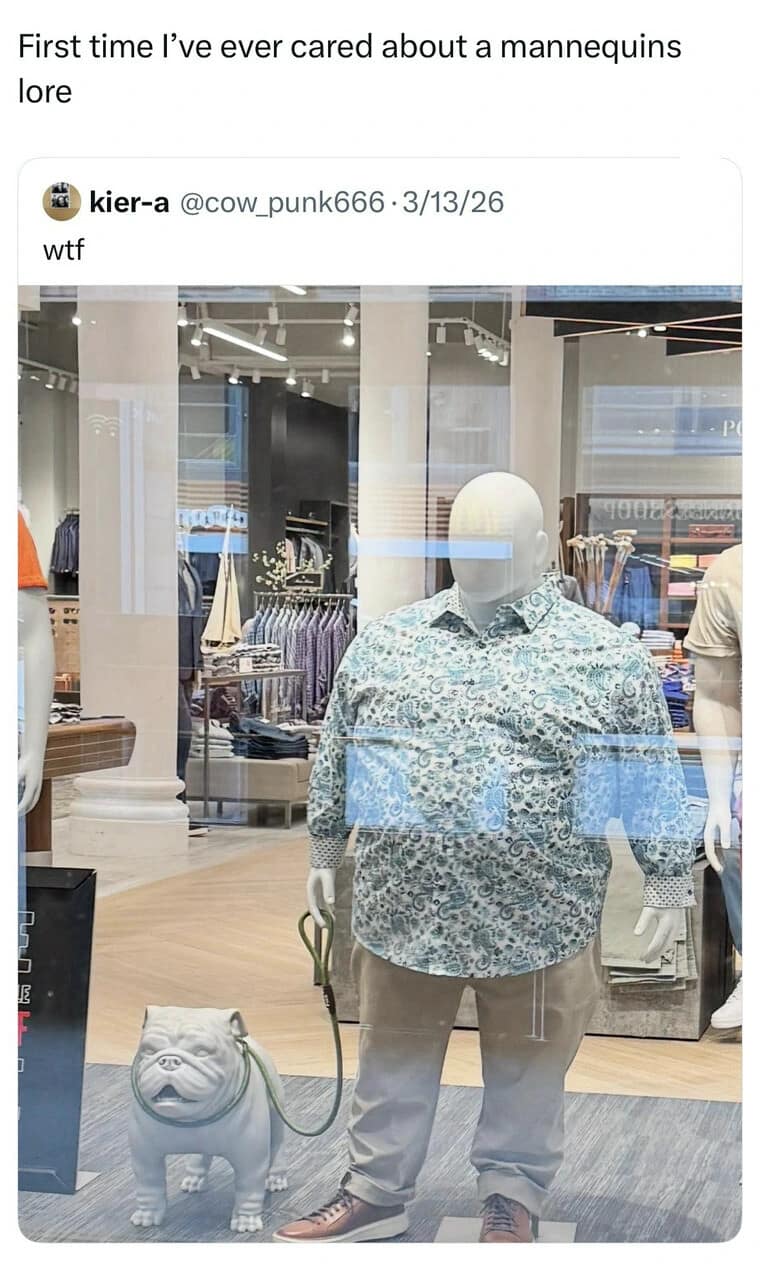 A retail window storefront display captured in a meme dump showcasing a stout, plus-sized male mannequin wearing a teal paisley button-up shirt and khaki trousers while holding a plastic bulldog on a leash.