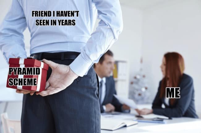 A corporate stock photo office meme from a meme dump showing a coworker in a dress shirt hiding a small wrapped red gift box behind his back labeled "PYRAMID SCHEME." The text above labels him as a "friend I haven't seen in years" who is stealthily approaching the narrator, labeled "ME," during a regular meeting.