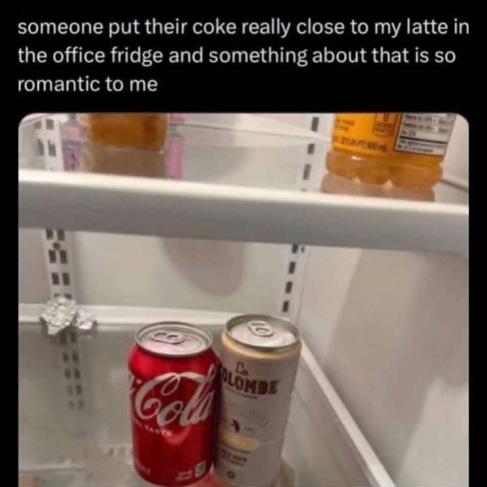 A meme dump photo of an office refrigerator shelf holding a red can of Coca-Cola and a La Colombe draft latte can positioned intimately close to one another, framed as a corporate workplace romance.