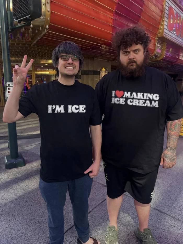 A funny matching apparel photo from a meme dump shows two friends standing on a city street, one wearing a shirt reading "I'M ICE" while his larger friend's shirt hilariously reads "I ❤️ MAKING ICE CREAM."