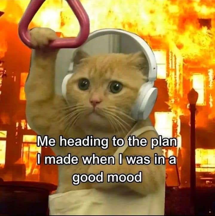A chaotic, disaster-vibe image macro common in current memes, showing a sad orange tabby cat wearing headphones and gripping a subway train ceiling strap while a massive building fire rages directly behind him, captioned: "Me heading to the plan I made when I was in a good mood."
