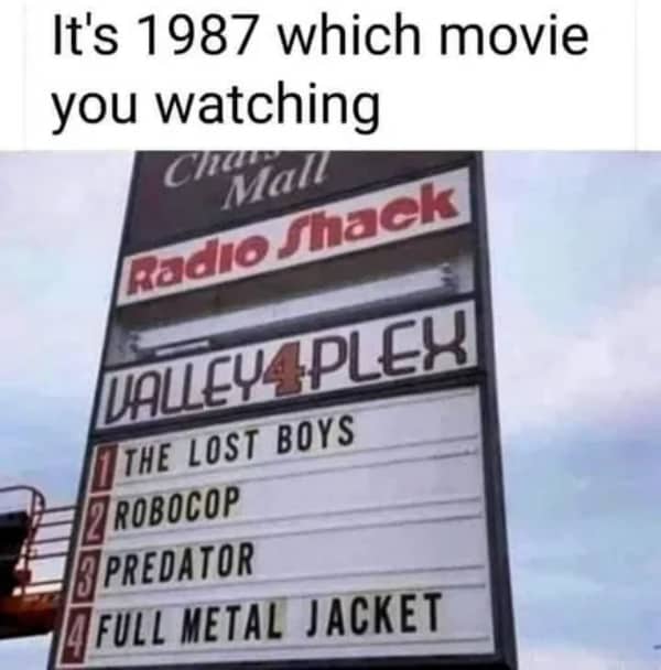 A retro marquee sign outside a local movie theater showing a legendary 1987 blockbuster lineup.