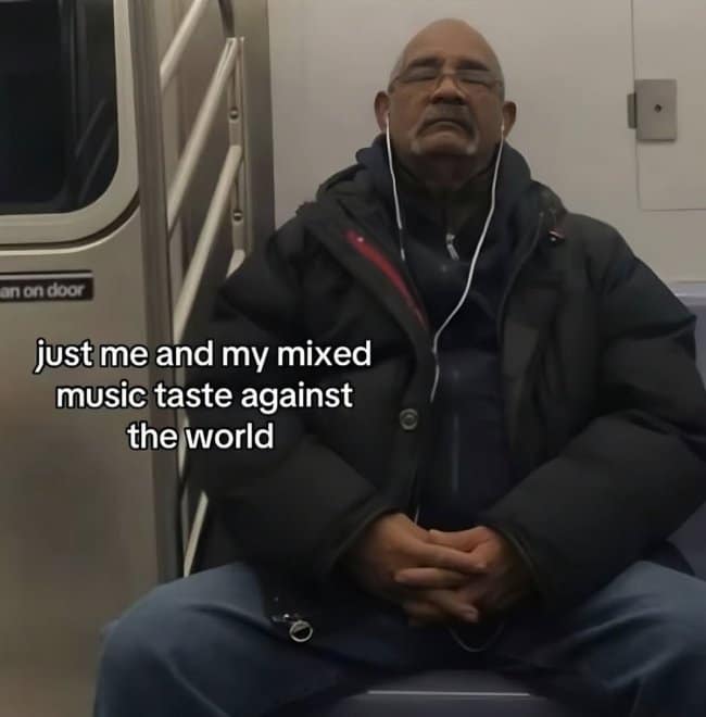 A relatable commuter music meme showing an older gentleman sitting on a subway train with his eyes closed, peacefully wearing earphones under the text, "just me and my mixed music taste against the world."