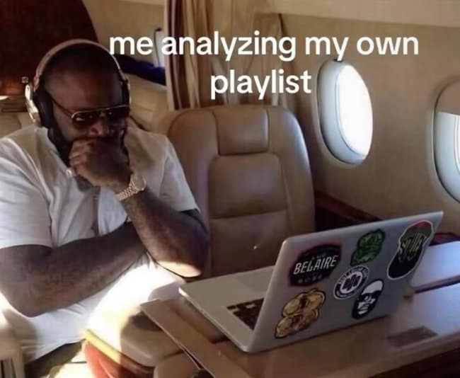 A luxury-tier playlist creation music meme displaying rapper Rick Ross sitting on a private jet, wearing studio headphones and staring intensely at a sticker-covered laptop screen with the text, "me analyzing my own playlist."