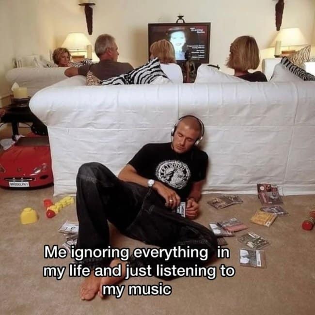 A nostalgic isolation music meme featuring a young David Beckham lying on the living room floor with headphones on, ignoring his family watching television on the couch behind him while surrounded by scattered CDs.