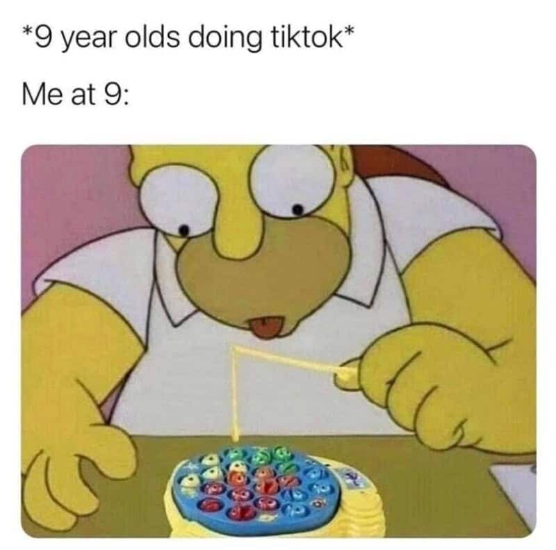 nostalgia meme comparing tech-savvy kids to 90s childhoods, featuring an image of Homer Simpson bug-eyed and fully focused on catching plastic spinning fish with a tiny toy fishing rod under the text "*9 year olds doing tiktok* Me at 9:".