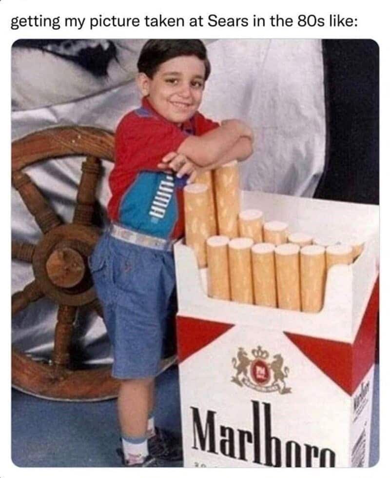A surreal, old-school nostalgia meme layout showing a vintage photo captioned "getting my picture taken at Sears in the 80s like:", featuring a young boy smiling and leaning casually against a giant novelty replica box of Marlboro cigarettes with a wooden ship's wheel behind him.