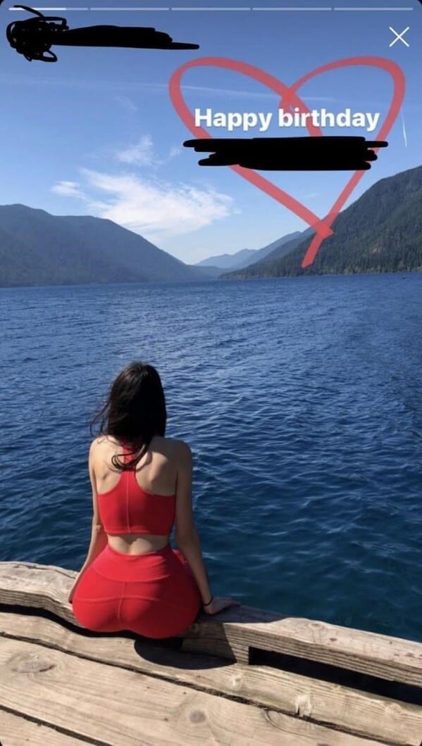 An Instagram story screenshot capturing a woman in a red activewear set looking out over a mountain lake, featuring a textbook photoshop fail where her hips are Liquified to exaggerated proportions, causing the straight lines of the wooden dock underneath her to comically sag and warp.