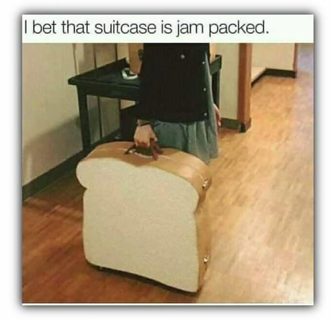 A delightfully absurd funny pun presentation highlights an unusual piece of luggage under the deadpan text, "I bet that suitcase is jam packed." The image captures a commuter walking through a building while carrying a large hardshell suitcase tailored to look exactly like a thick slice of white sandwich bread with a realistic golden crust.