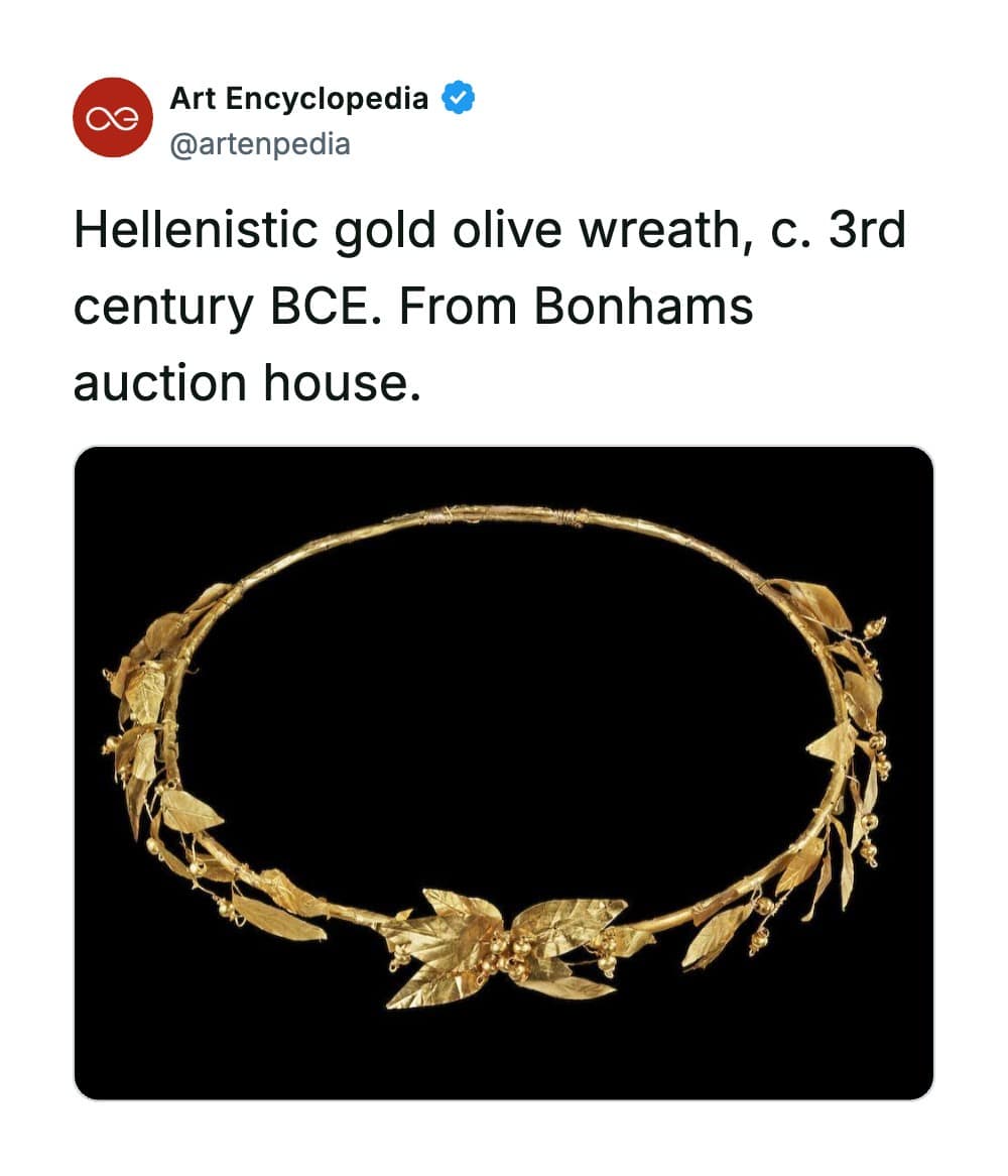 A rare historical photo capturing a remarkably delicate Hellenistic gold olive wreath from the 3rd century BCE, featuring a slender gold ring adorned with hand-beaten gold leaves and small olive cluster beads.
