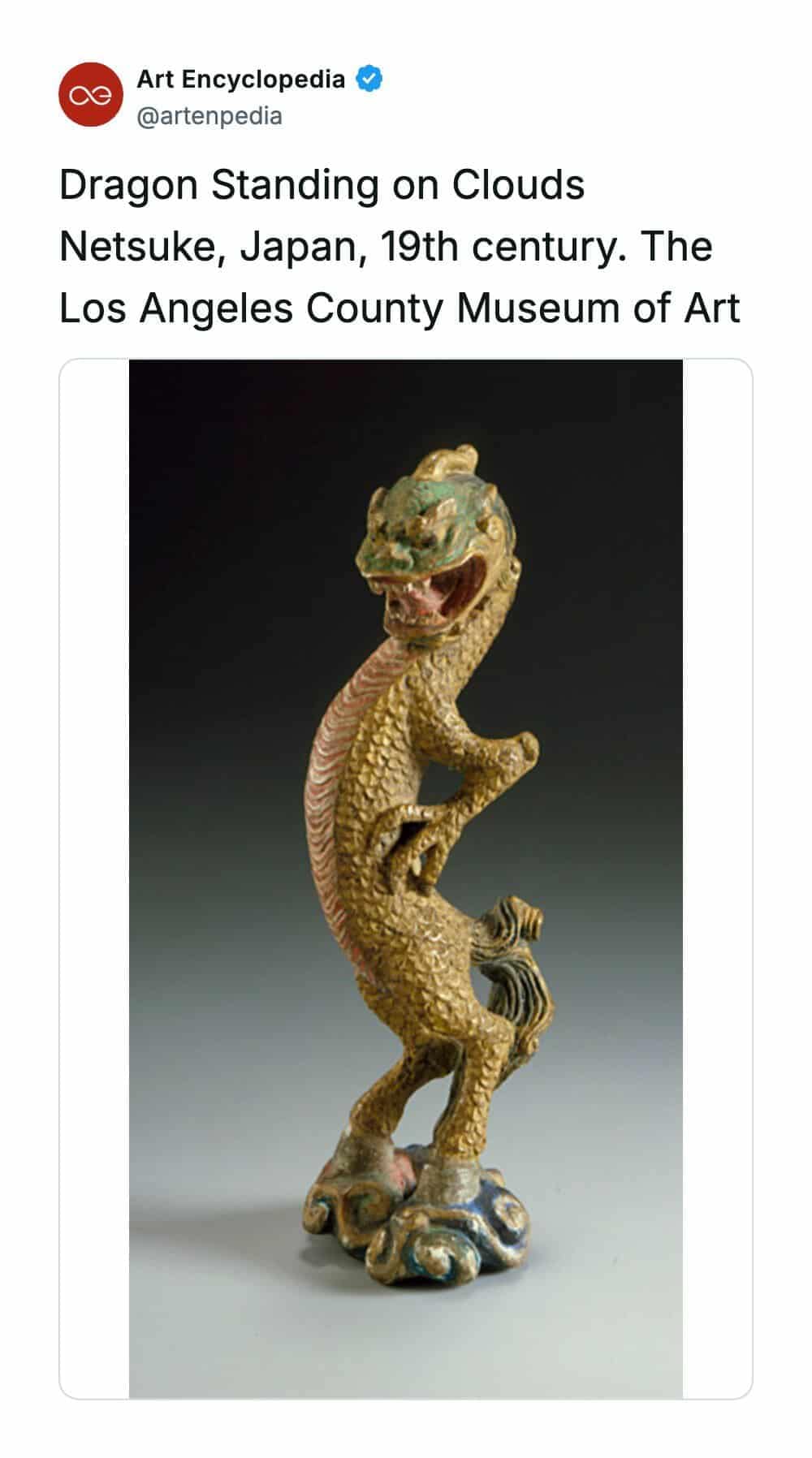 A rare historical photo capturing a 19th-century Japanese Netsuke carving titled 'Dragon Standing on Clouds' from the Los Angeles County Museum of Art. The miniature golden-scaled dragon sculpture stands upright on its hind legs atop a stylized blue and white cloud base, striking a dynamic, sassy pose with one arm dramatically crooked.