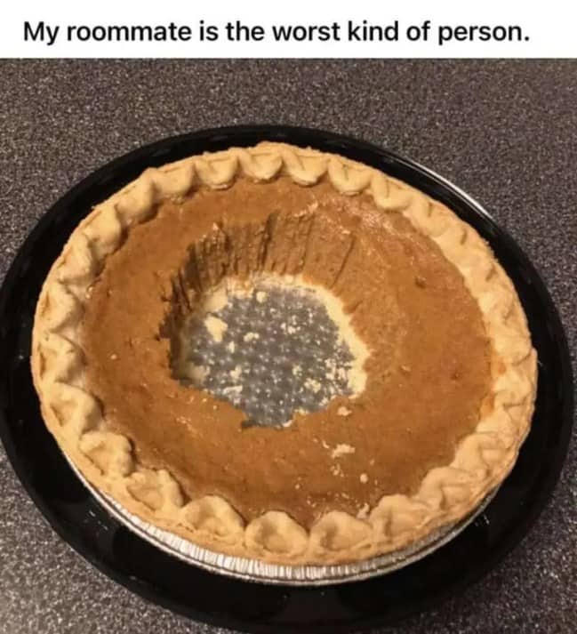 Whole pumpkin pie with a massive circular crater eaten exclusively out of the middle section.