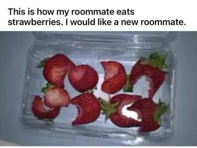 Clear plastic container filled with fresh strawberries that have all been bitten in half.