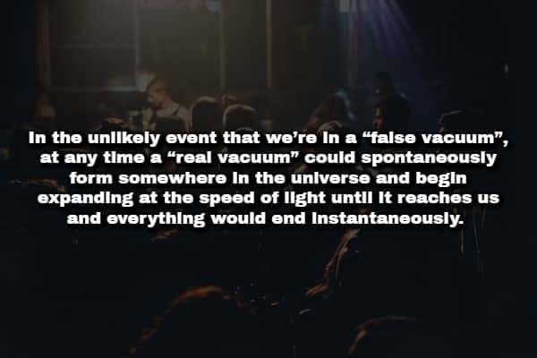 Darkened concert crowd with text about a false vacuum destroying the universe at light speed.