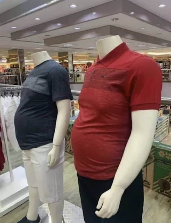 Two retail clothing store mannequins realistically designed with large prominent beer bellies.