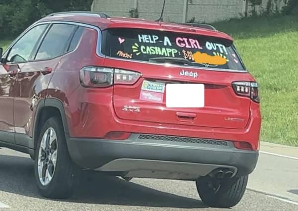 Red Jeep with hand-written text on rear window asking to help a girl out via CashApp.