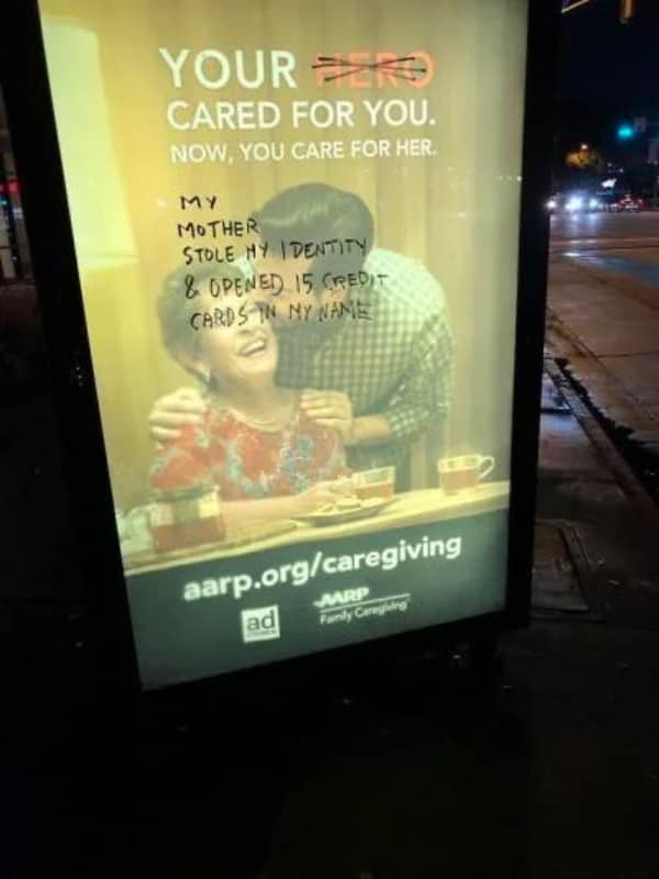 AARP billboard defaced with handwritten text claiming a mother stole an identity and opened fifteen credit cards.