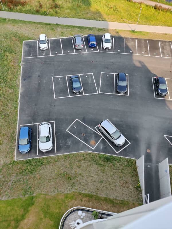 An aerial view of a parking lot where a few spaces are painted at completely random angles.