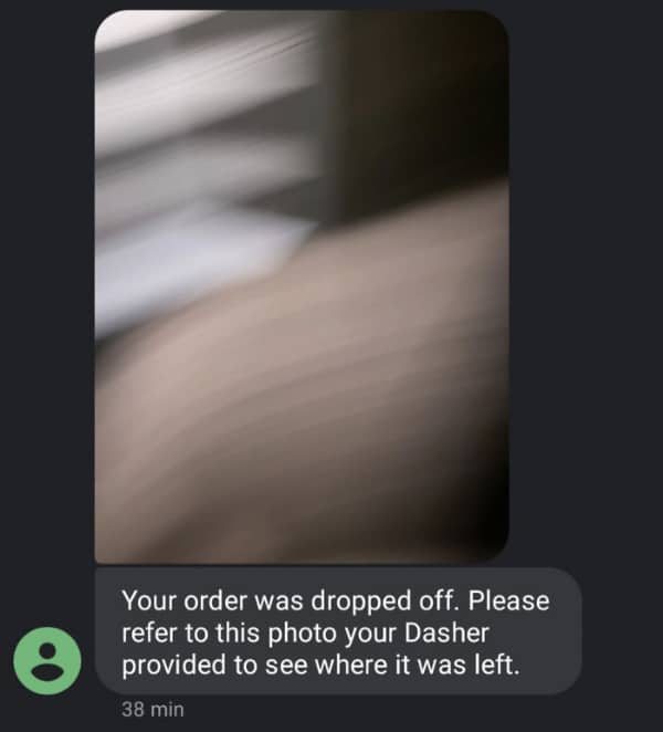 A delivery app notification showing a completely blurry out of focus photo from a driver.
