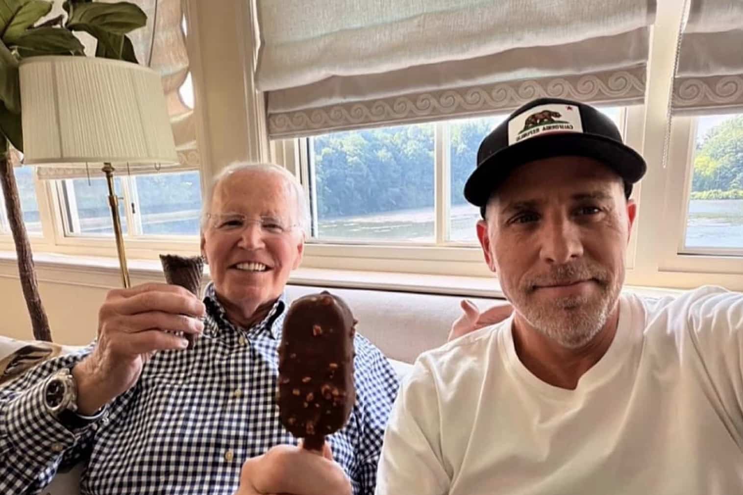 Joe Biden and a man smiling while holding ice cream cones and bars indoors.