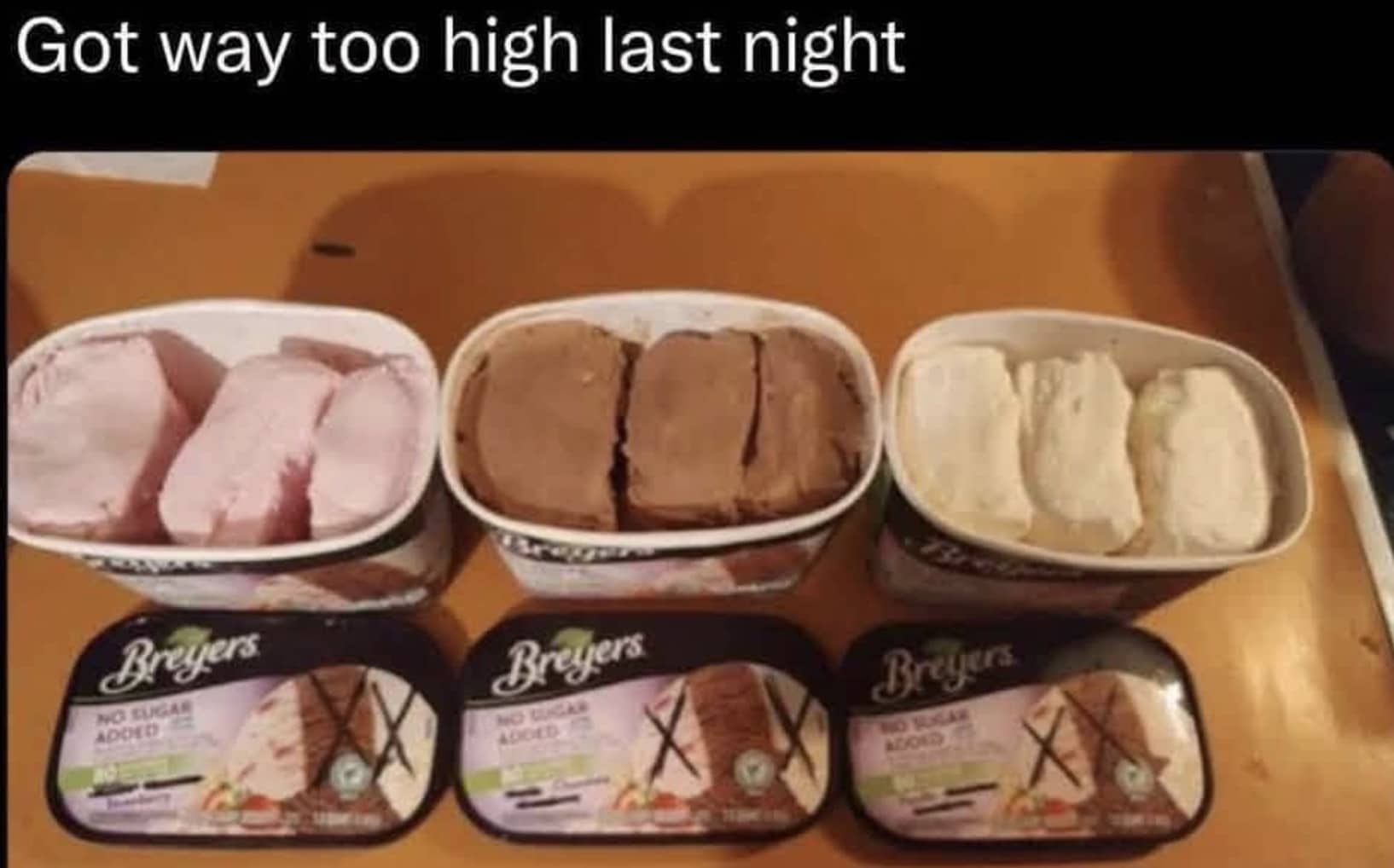 Three tubs of Breyers ice cream separated into strawberry chocolate and vanilla flavors horizontally.