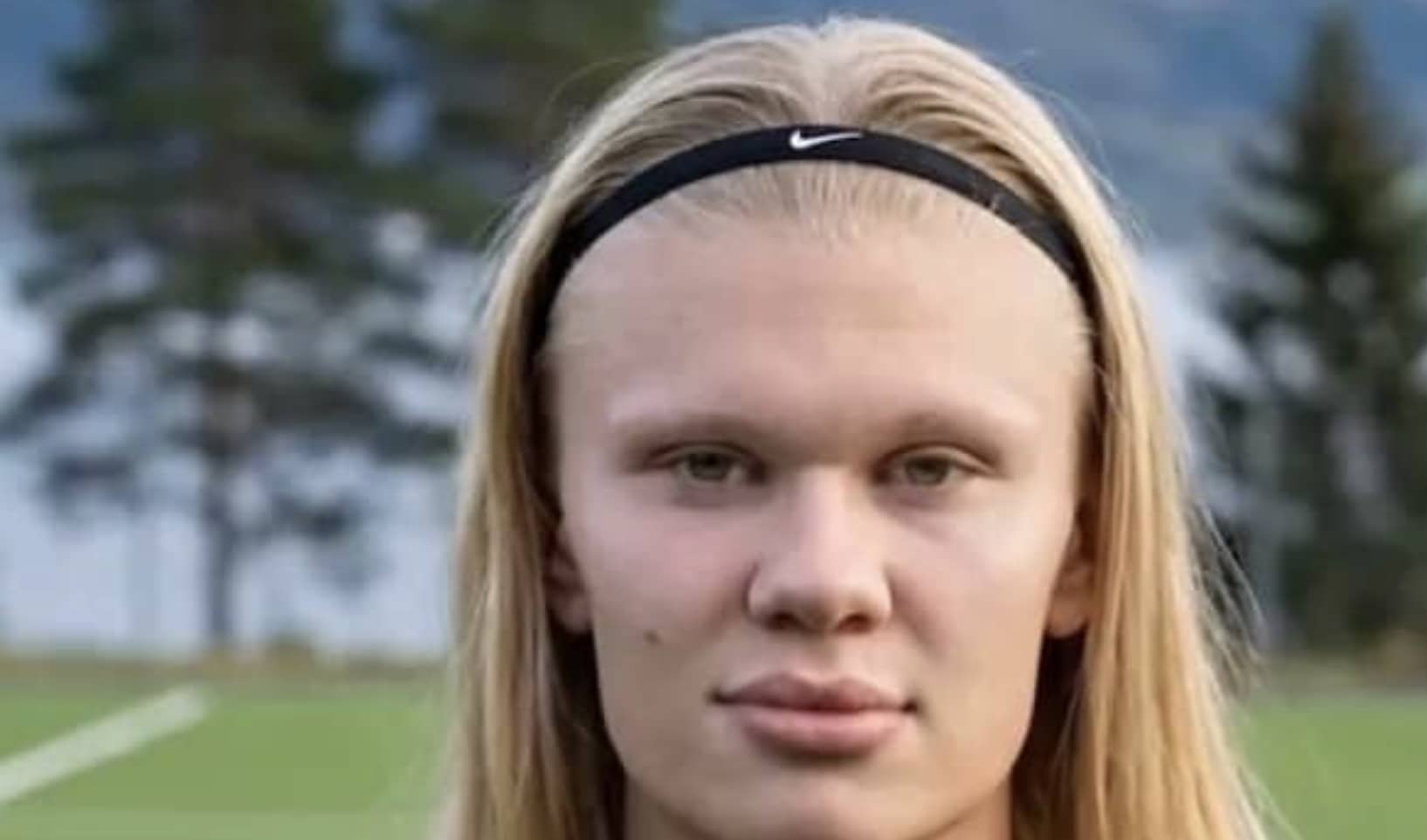 Portrait of professional soccer player Erling Haaland wearing a black Nike headband outdoors.