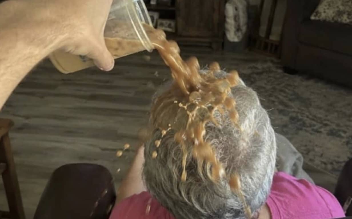 Iced coffee being poured directly onto an older person's head for funny memes internet content.