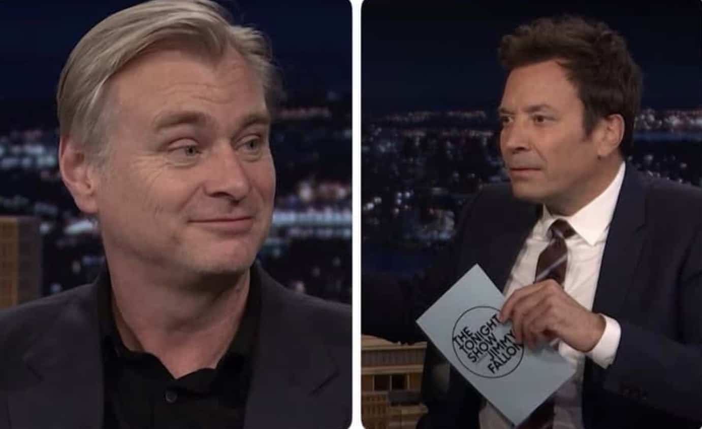 Christopher Nolan smiling side by side with Jimmy Fallon holding a talk show cue card.