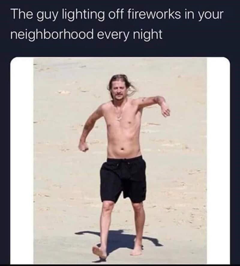 A hilariously accurate 4th of july meme targets neighborhood summer disruptions with a candid photograph of a shirtless, long-haired Kid Rock walking awkwardly along a sandy beach in black swim trunks. The dark text layer overhead states: "The guy lighting off fireworks in your neighborhood every night," mocking local backyard pyrotechnicians.