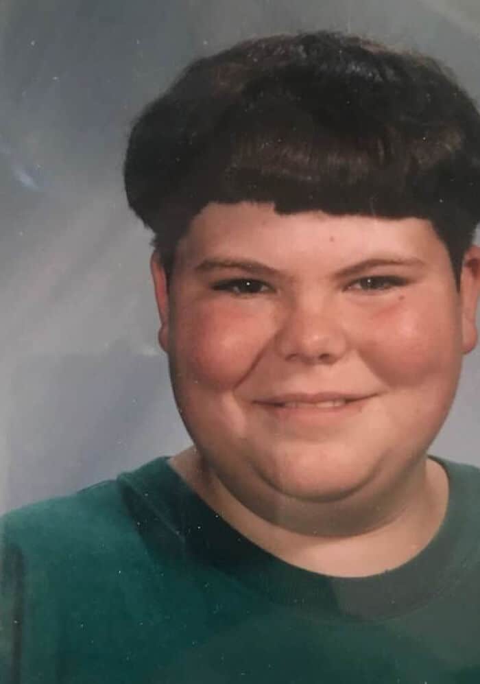 Vintage school portrait of a boy with a dense, thick round bowl cut.