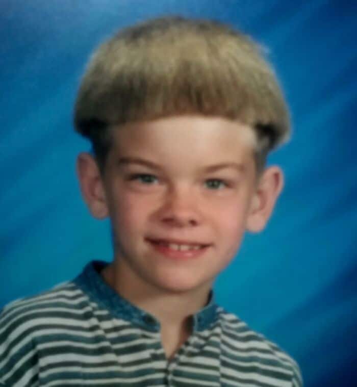 School picture of a boy with a blonde bowl cut and buzzed sides.