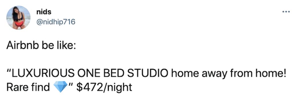 A listing-parody airbnb meme features a screenshot of a short tweet from user nids (@nidhip716). The copy mimics over-the-top corporate marketing headlines, stating: "Airbnb be like: 'LUXURIOUS ONE BED STUDIO home away from home! Rare find 💎' $472/night".