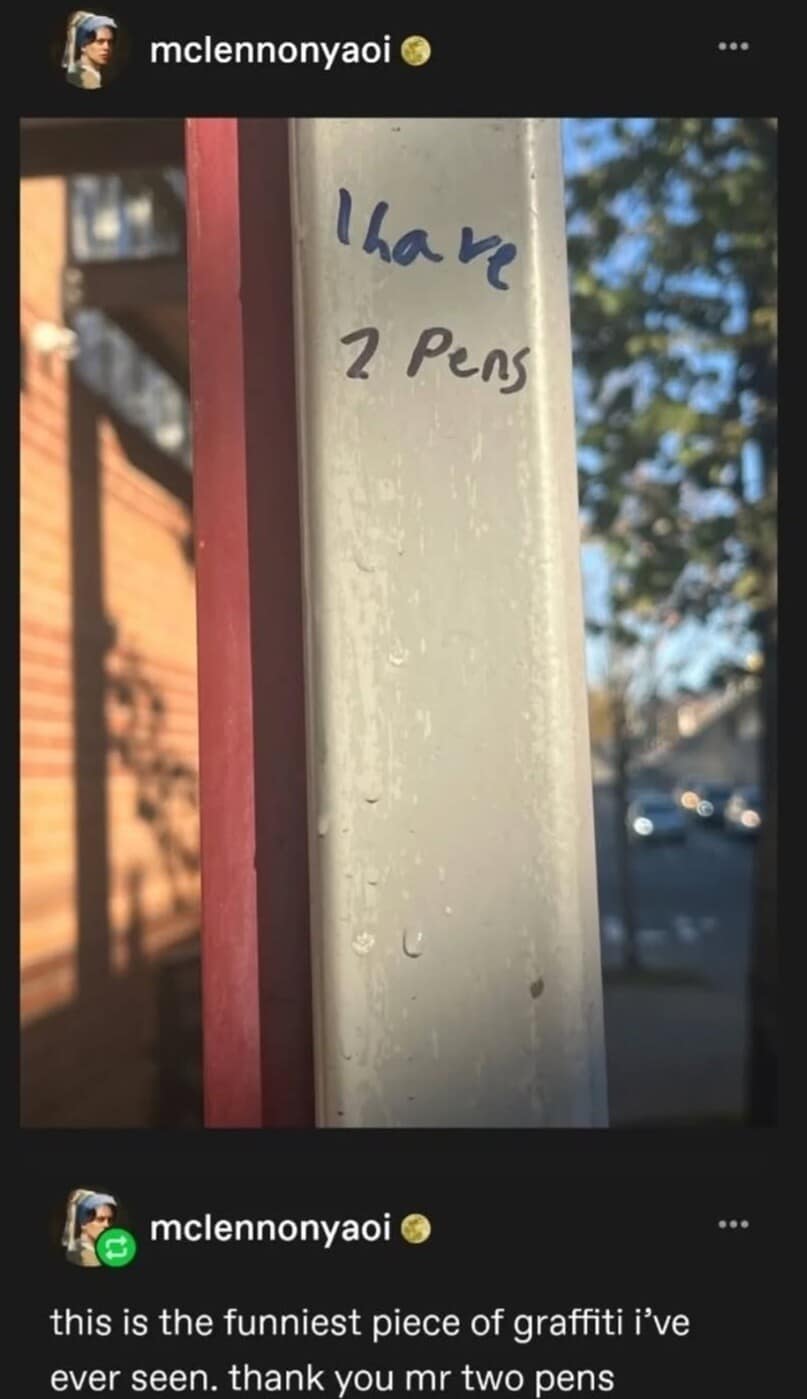 A text-based post captured as a classic meme displaying a simple blue ink message scrawled onto a white public pillar that reads "I have 2 pens," celebrated by a commentator as the absolute pinnacle of minimalist public graffiti art.