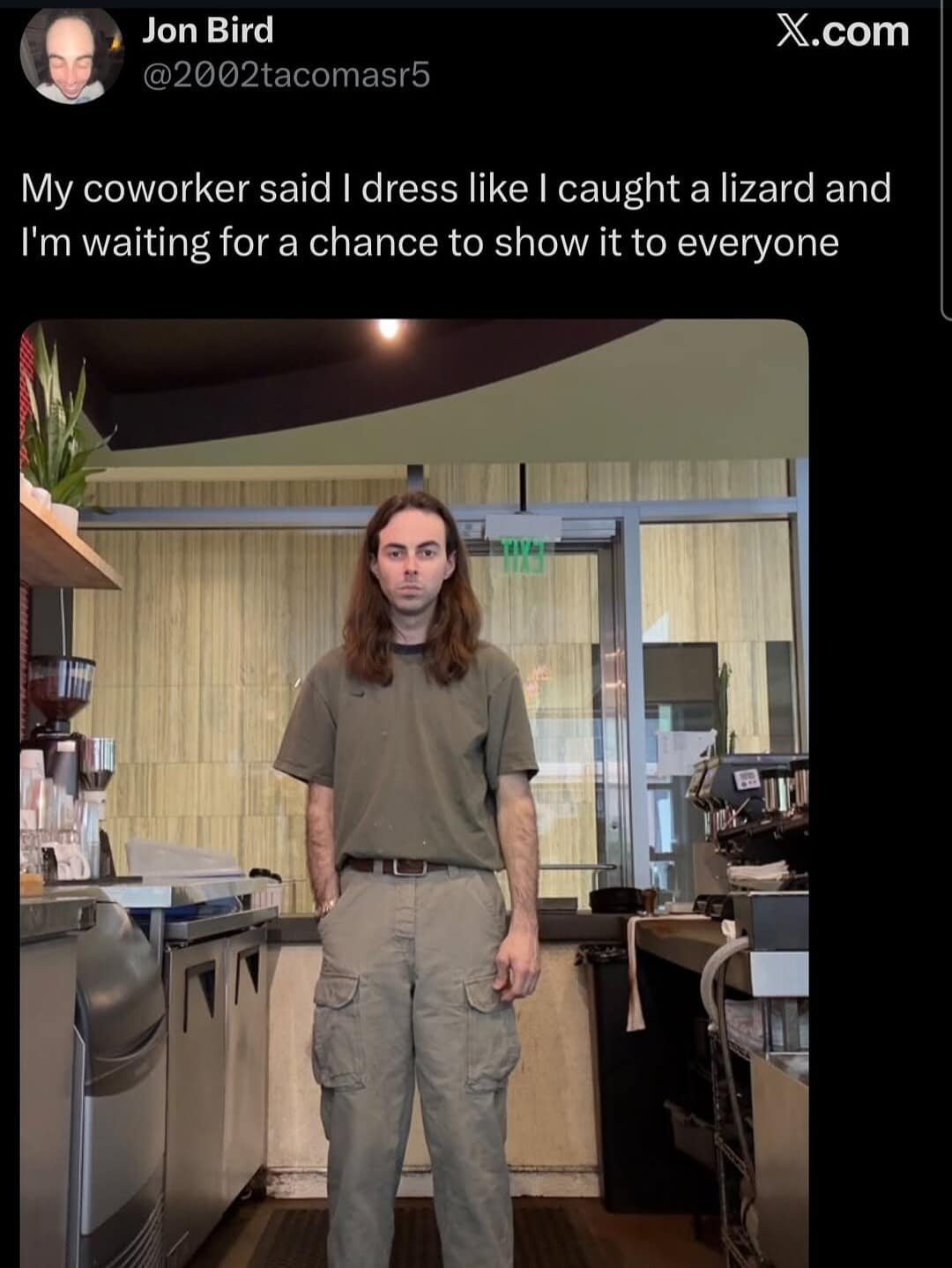 A highly specific fashion insult post shows a long-haired barista standing in a cafe kitchen wearing a plain olive t-shirt tucked into deep cargo pants, perfectly suiting his coworker's claim that he looks like he just caught a lizard and is waiting to show everyone.
