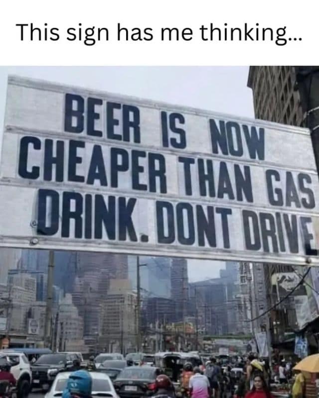 A funny classic meme highlighting an ironic marquee sign over heavy city traffic that states beer is cheaper than gas, advising people to drink and not drive.