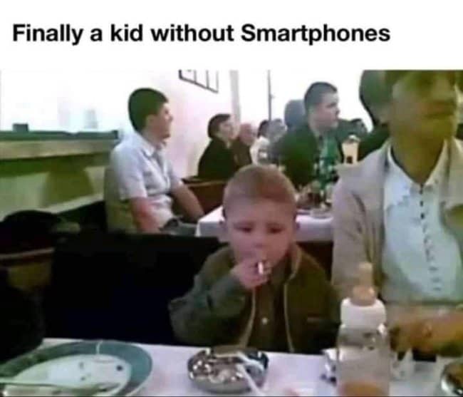 Small child holding a lit cigarette at a dinner table anti-smartphone dark meme.
