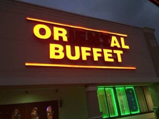 A broken Oriental Buffet neon sign glowing at night to read OR IAL BUFFET.