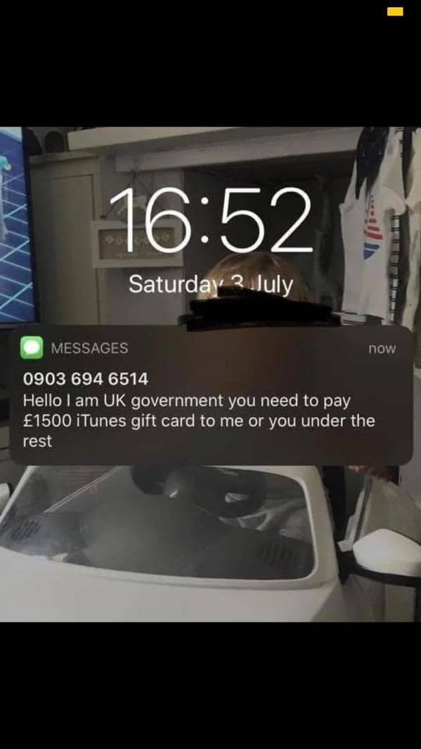 Lock screen showing a text message scammer claiming to be the UK government demanding gift cards.