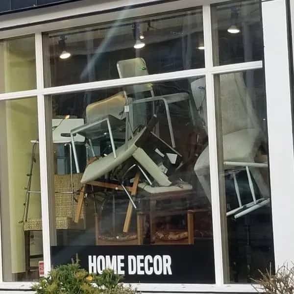 Funny meme showing stacked and messy chairs behind a home decor storefront window.
