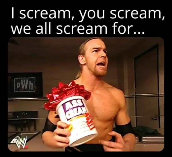 A nostalgic wrestling-themed funny meme features WWE's Christian Cage screaming aggressively into the camera while holding up a giant holiday-gift-wrapped tub labeled "ASS CREAM."
