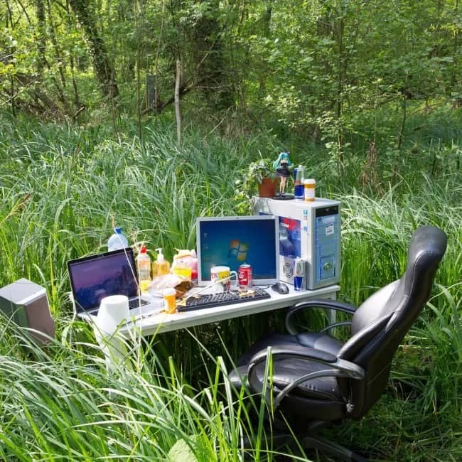 Funny memes showing an outdoor PC gaming desk setup hidden in tall green grass.