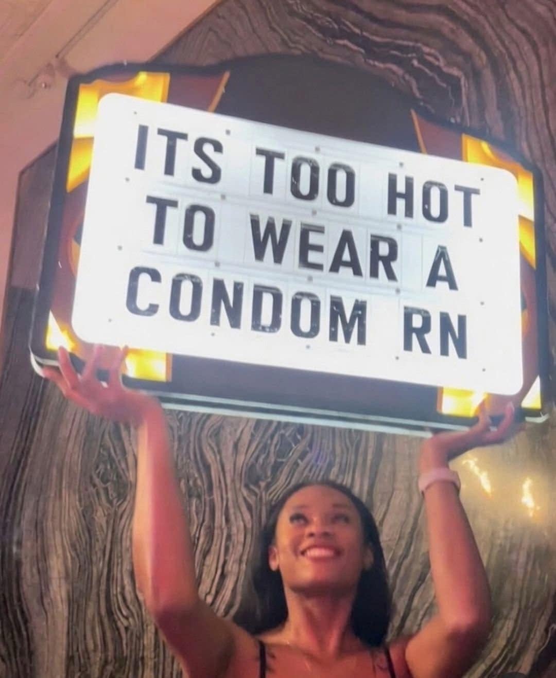 An entertaining picture from a social meme dump captures a woman smiling while holding up a light-up sign with a wild summer warning.