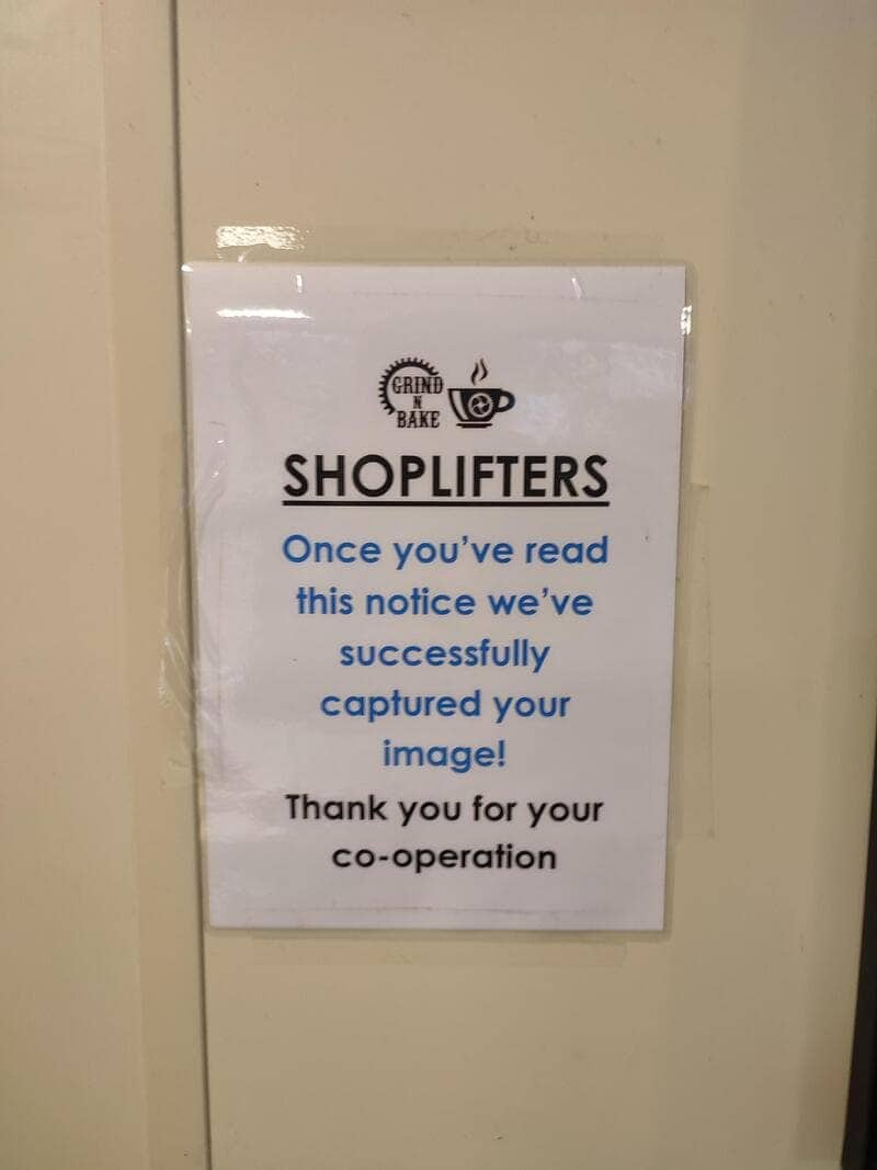 Clever sign joke warning shoplifters that reading the paper notice captures their image successfully.