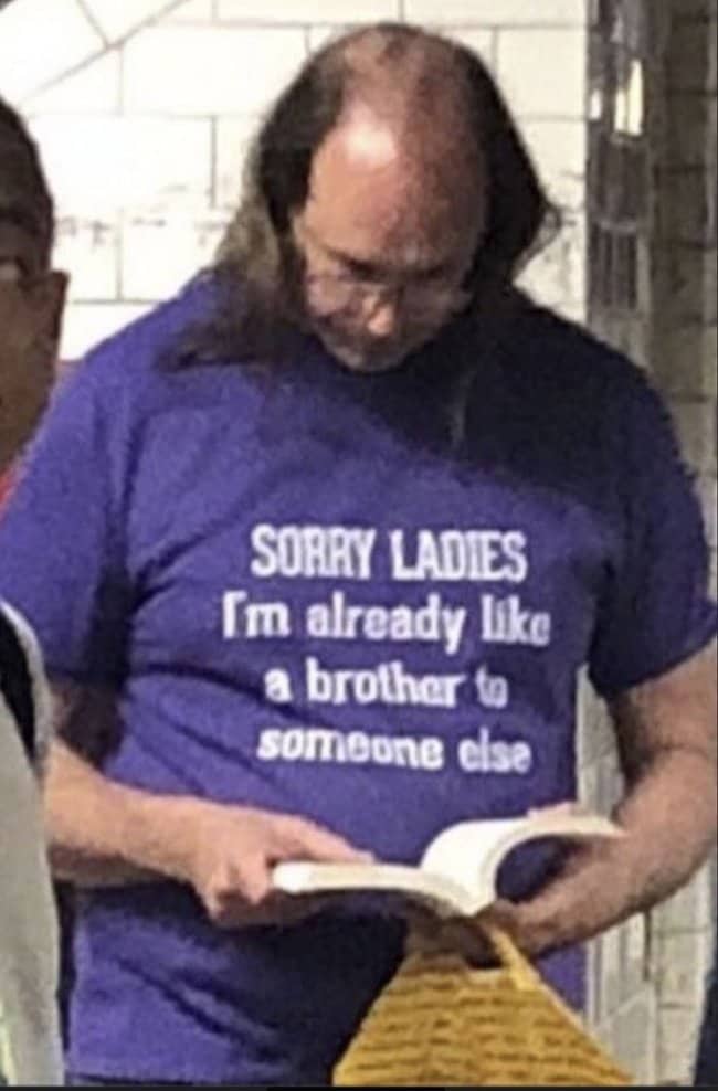Man reading book wearing friendzone brother joke shirt showcasing awkward trends in funny outfits.