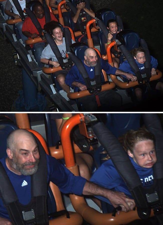 A man grinning and holding a terrified young girl's hand tight on a rollercoaster loop.